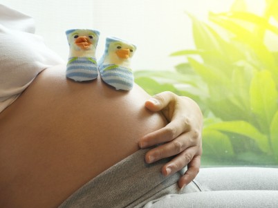 Baby shoes on pregnant belly